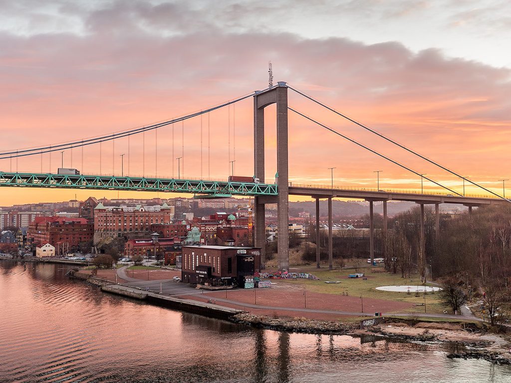 The Älvsborg Bridge crossing the Göta River in Gothenburg during sunset with warm clouds above.
