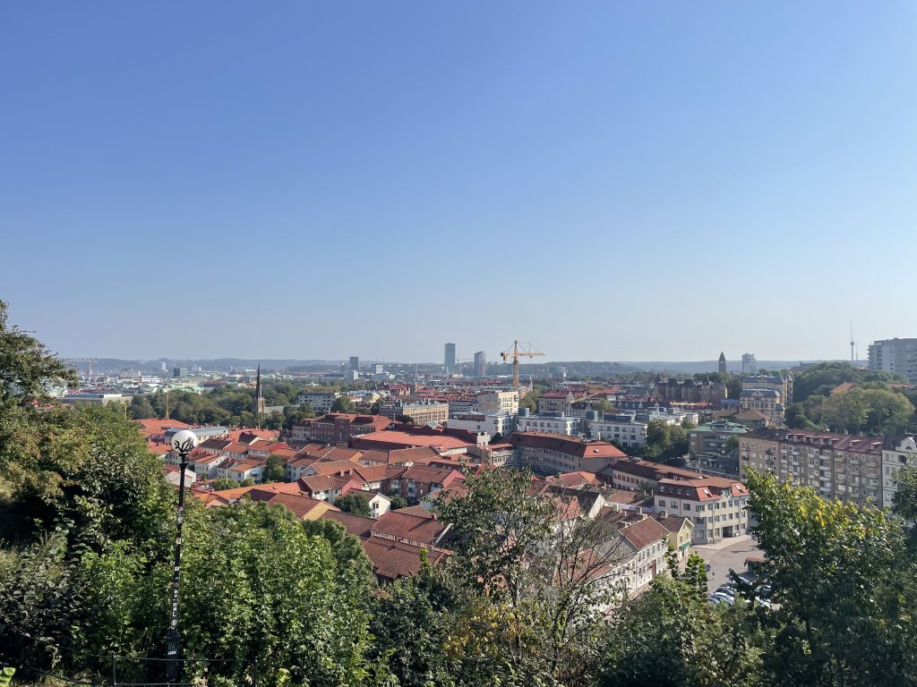 View over Gothenburg from Skansen Kronan, showing rooftops and skyline under a pale blue sky.