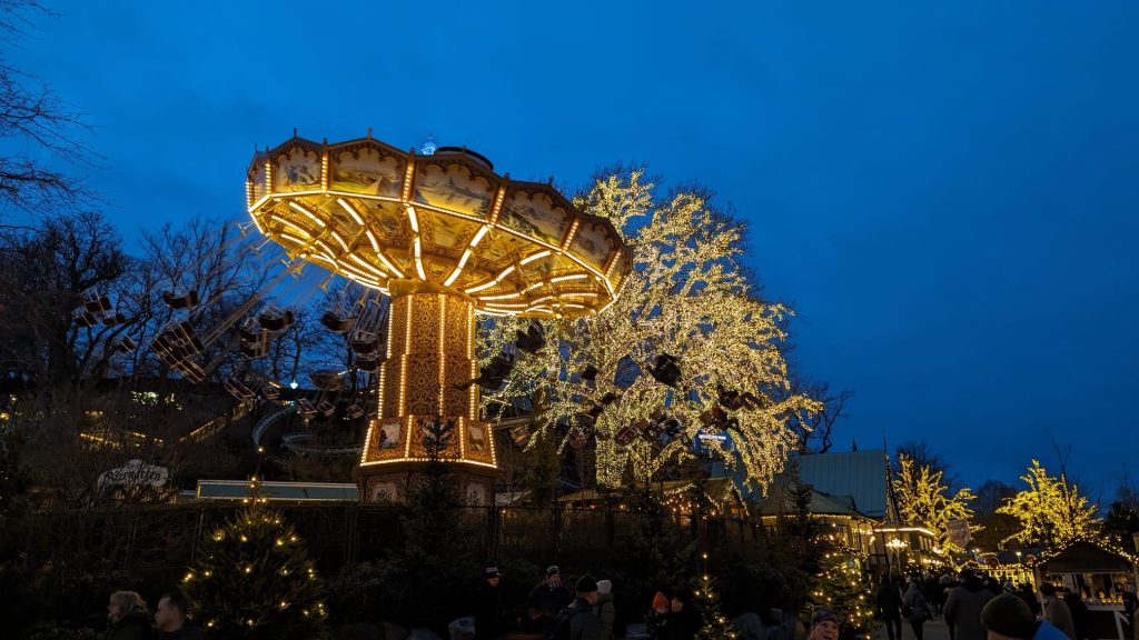 Illuminated swing carousel and Christmas lights at night in Liseberg Amusement Park, Gothenburg.