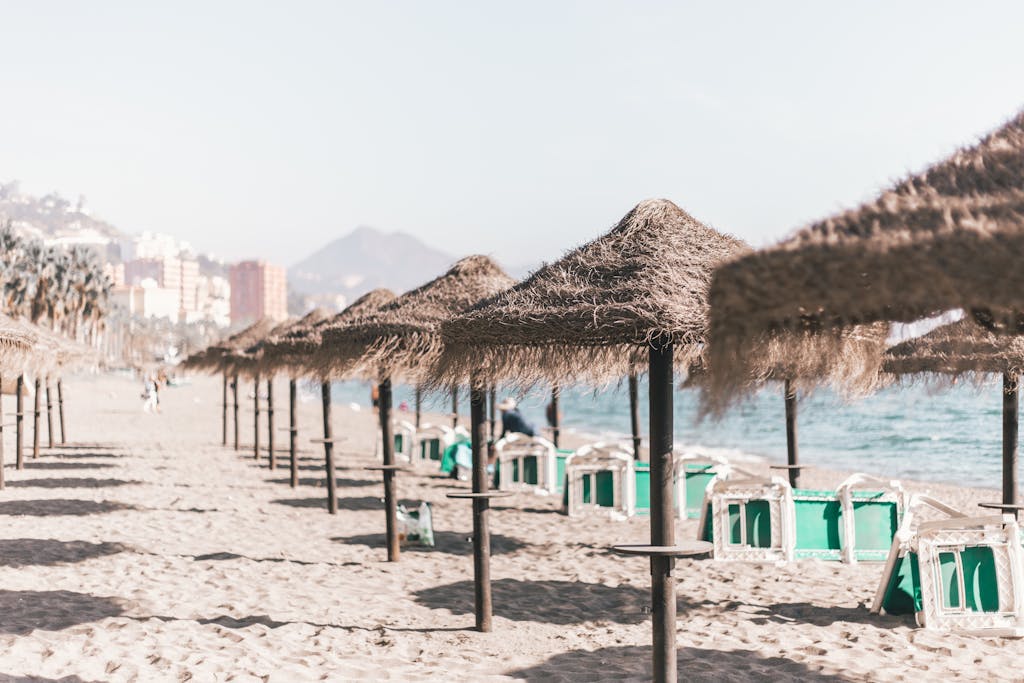 A serene sandy beach in Malaga with straw umbrellas and clear skies, perfect weather for a budget weekend trip
A serene sandy beach with straw umbrellas and clear skies, perfect for a summer vacation in Malaga, Spain.