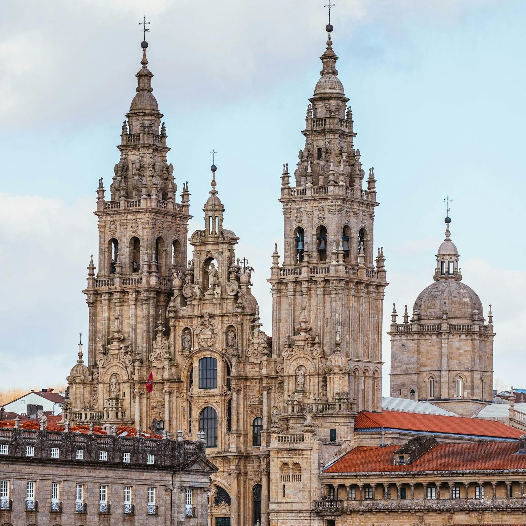 The majestic Santiago de Compostela Cathedral rises above the historic city's rooftops, showcasing Gothic architecture.