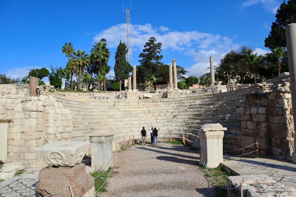 Ancient Roman amphitheater ruins in Alexandria with marble seating and scattered columns.