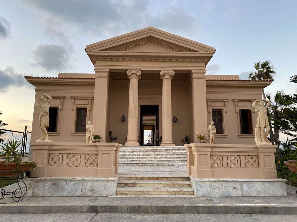 Neoclassical mansion with columns and statues, part of the Greco-Roman Museum in Alexandria.