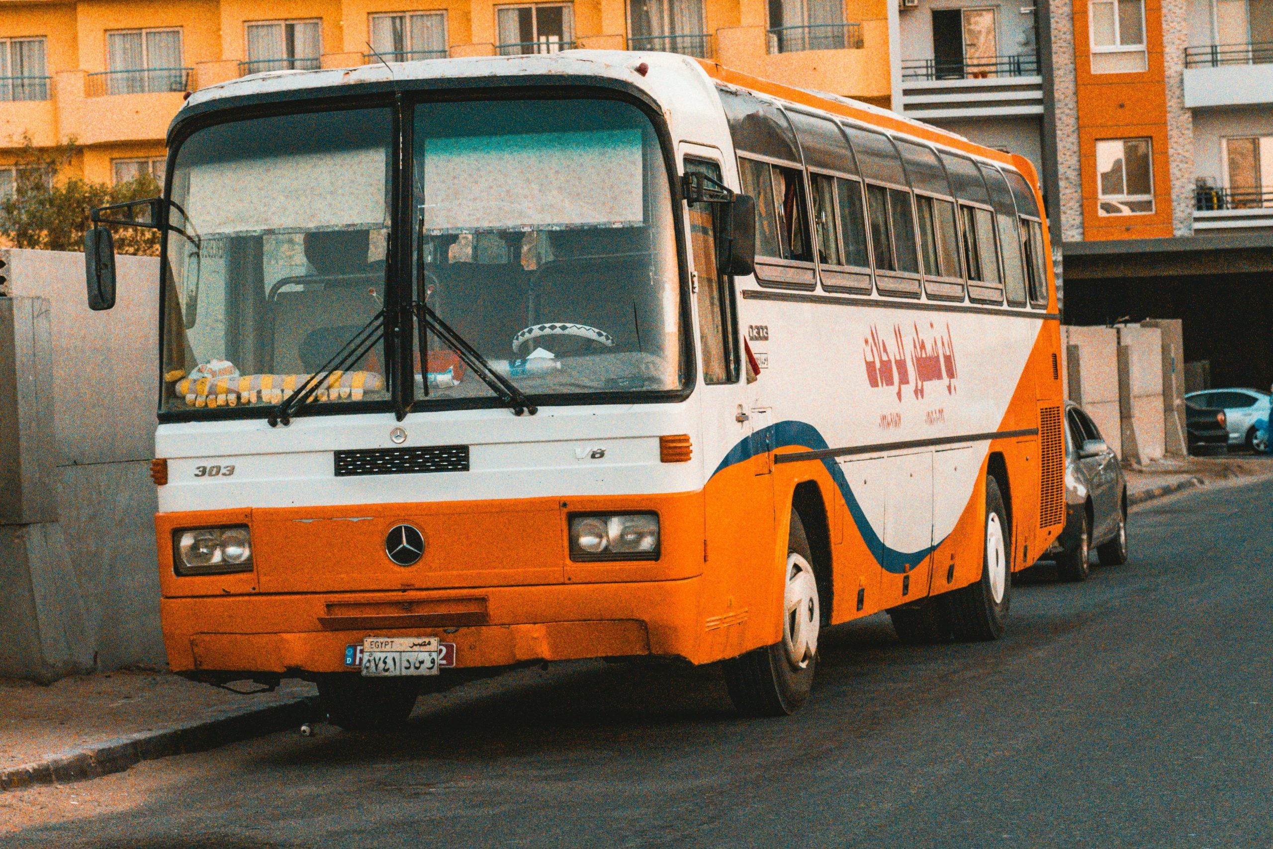 Old orange and white Mercedes bus used for intercity travel in Egypt.