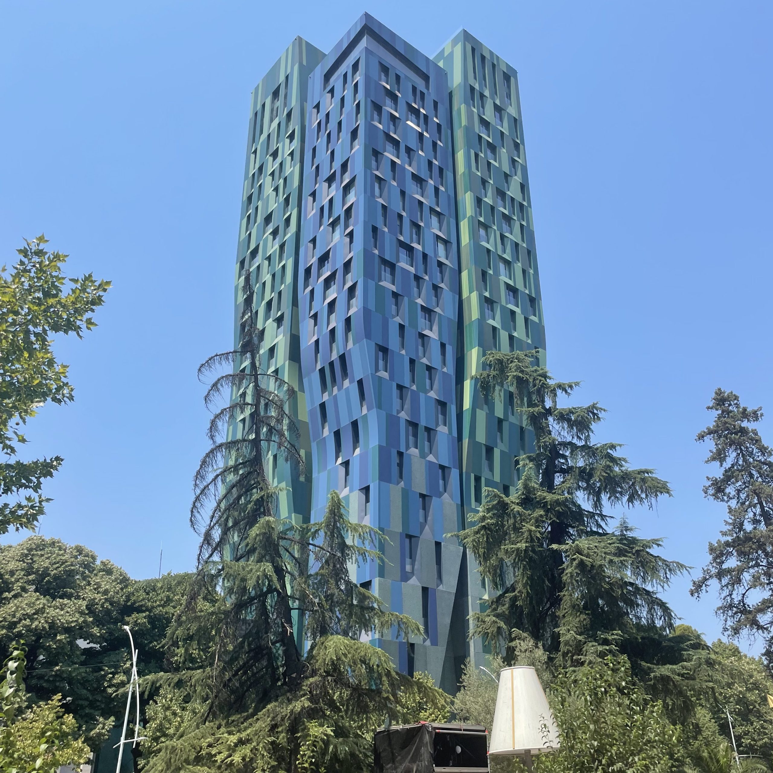 Modern high-rise Alban Tower in Tirana, Albania with green and blue façade.