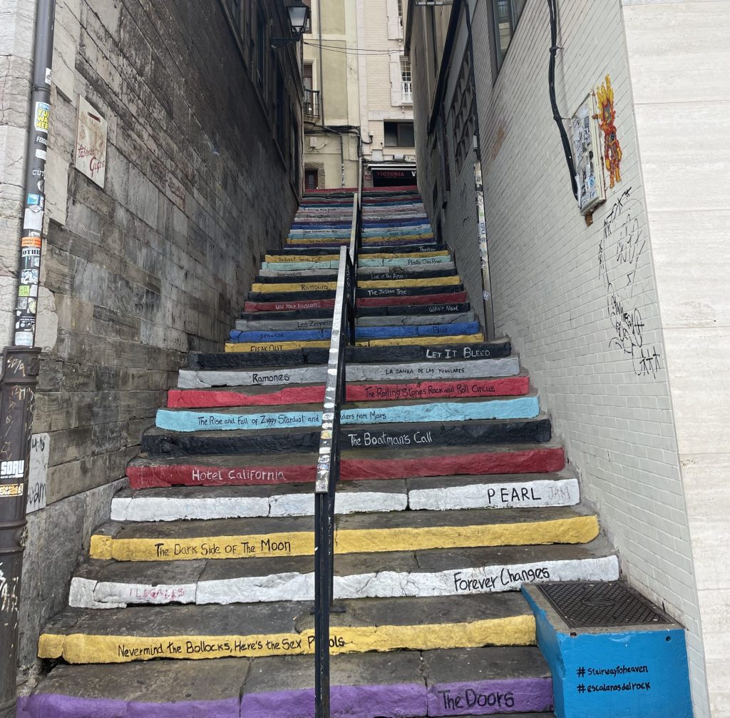 Stairway of Rock in Gijon, Asturias, Spain, painted with names of famous rock albums like Hotel California and Dark Side of the Moon.