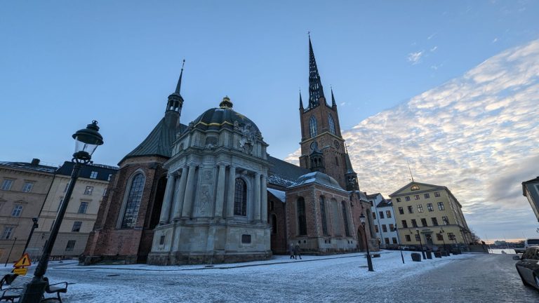 Exterior of Riddarholmen Church with gothic spire and light snowfall in Stockholm