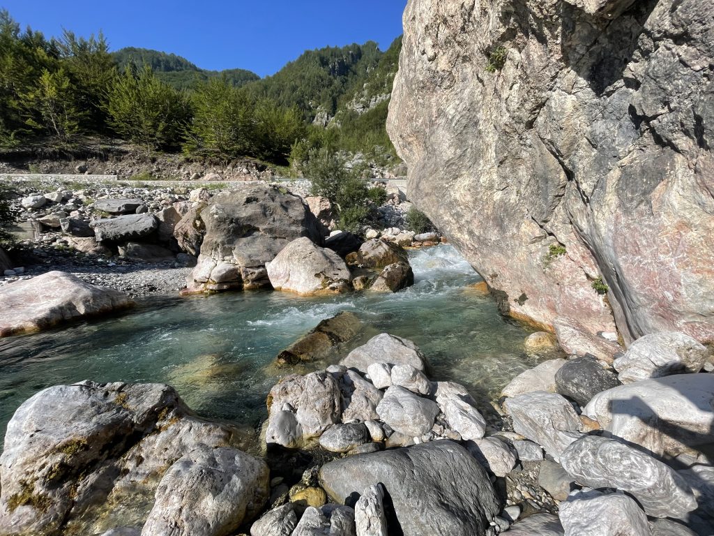 Clear blue river flowing through Theth valley in Albania.
