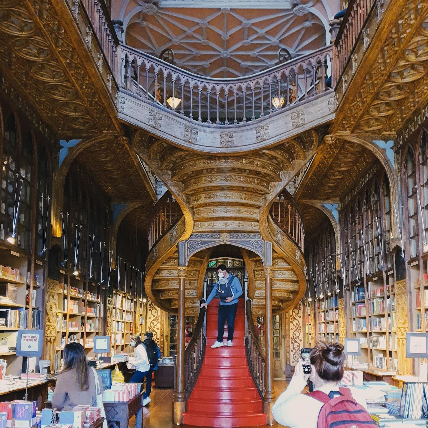 Explore the stunning interior of Livraria Lello, featuring its iconic red staircase in Porto, Portugal.