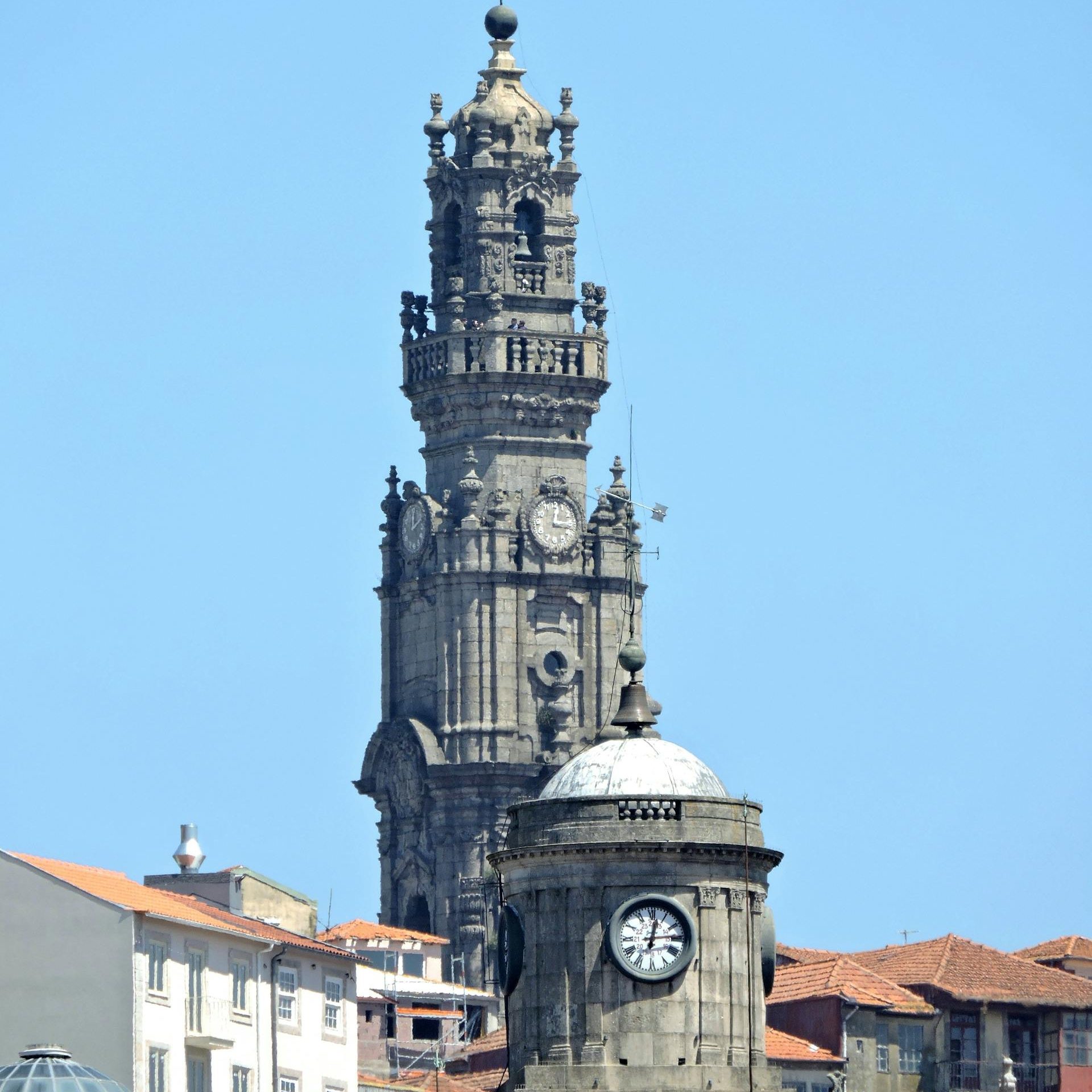 Iconic Clerigos Tower in Porto, Portugal, dominates the skyline under a clear blue sky.