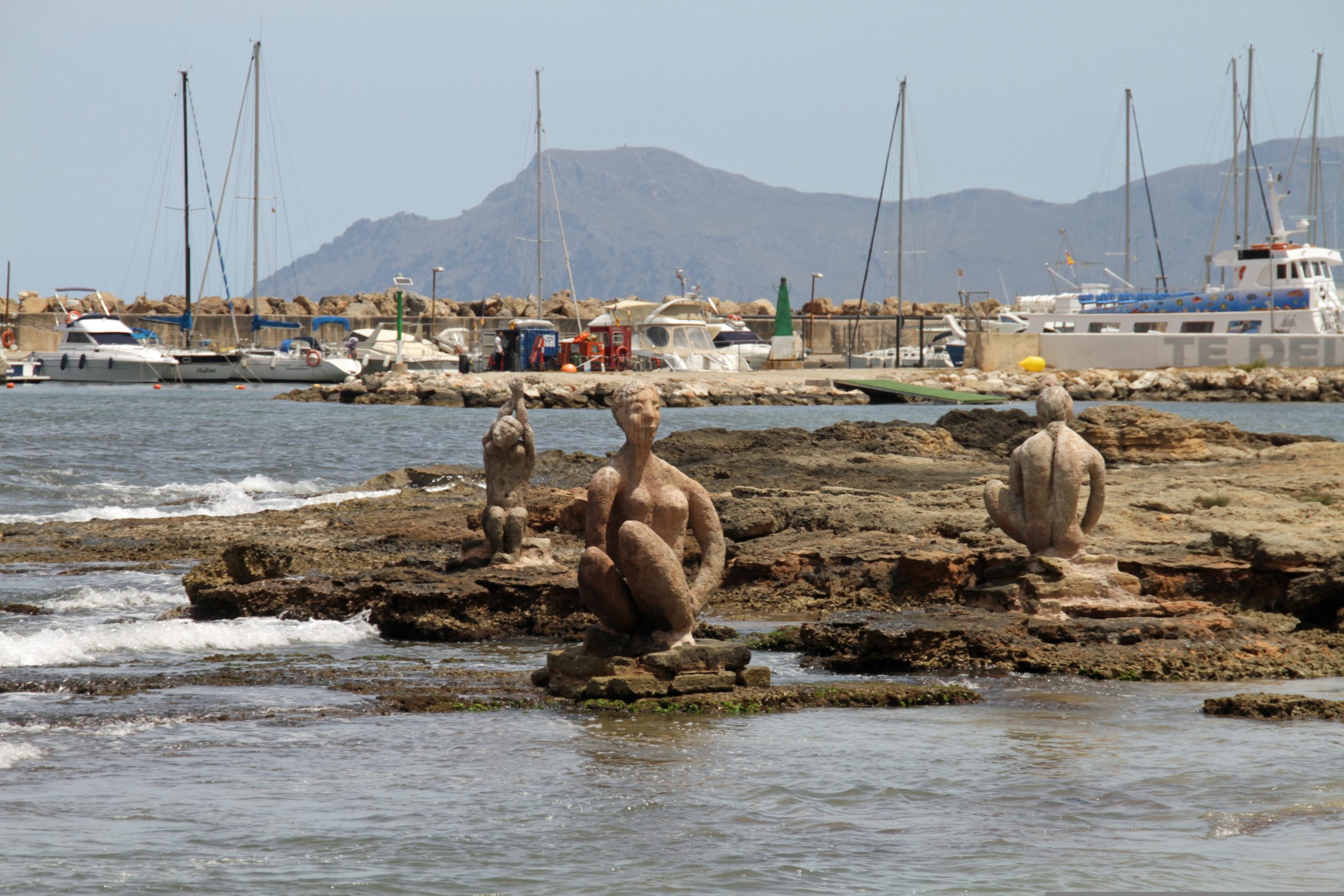 Stone sculptures of women in the sea at Can Picafort harbor, Mallorca