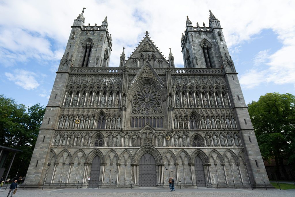 Front view of Nidaros Cathedral in Trondheim, Norway, showcasing its Gothic architecture, stone carvings, and twin towers under a partly cloudy sky. seen on things to do in Trondheim