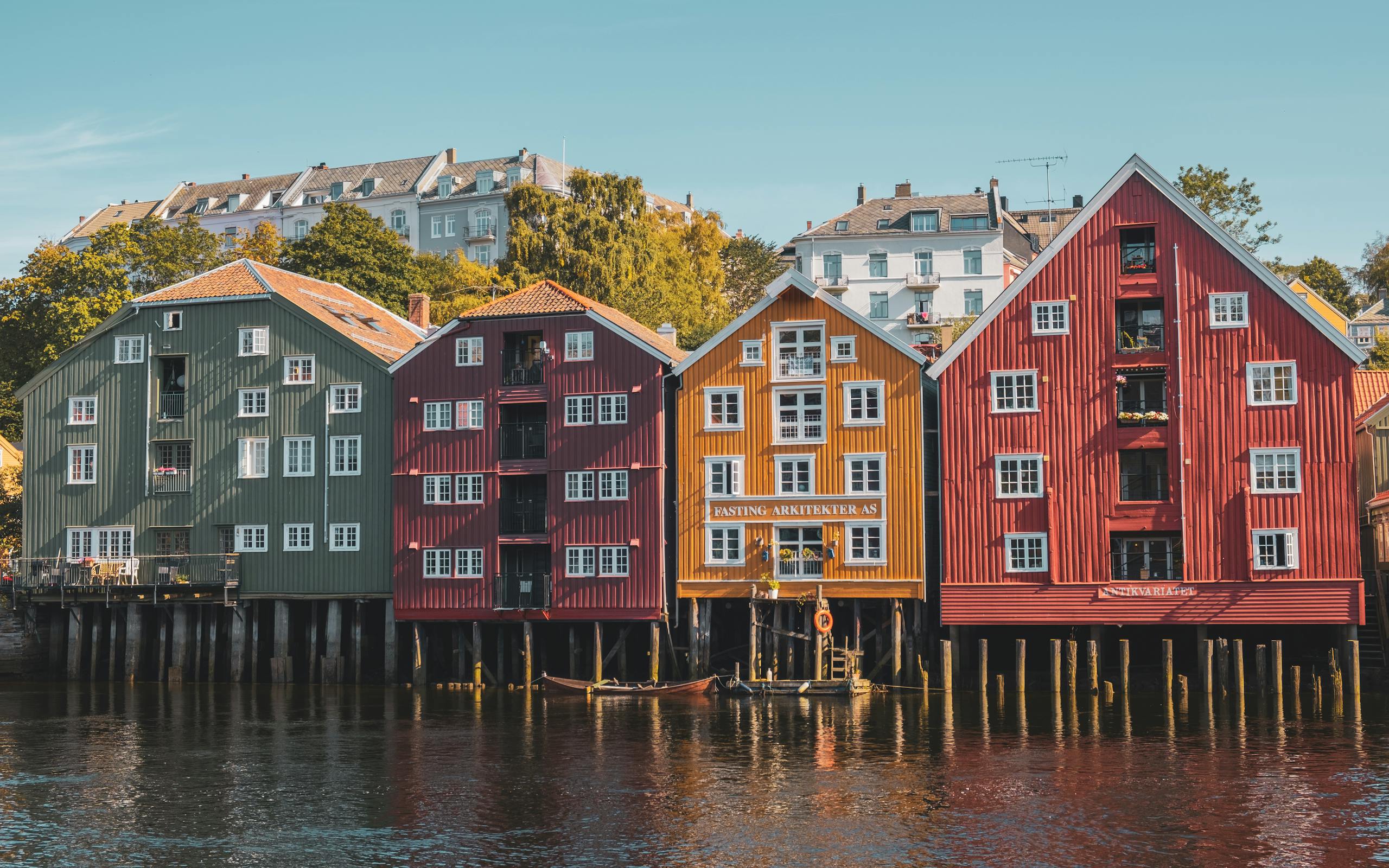 Traditional wooden houses along the river in Trondheim, Norway. A vibrant display of heritage architecture.