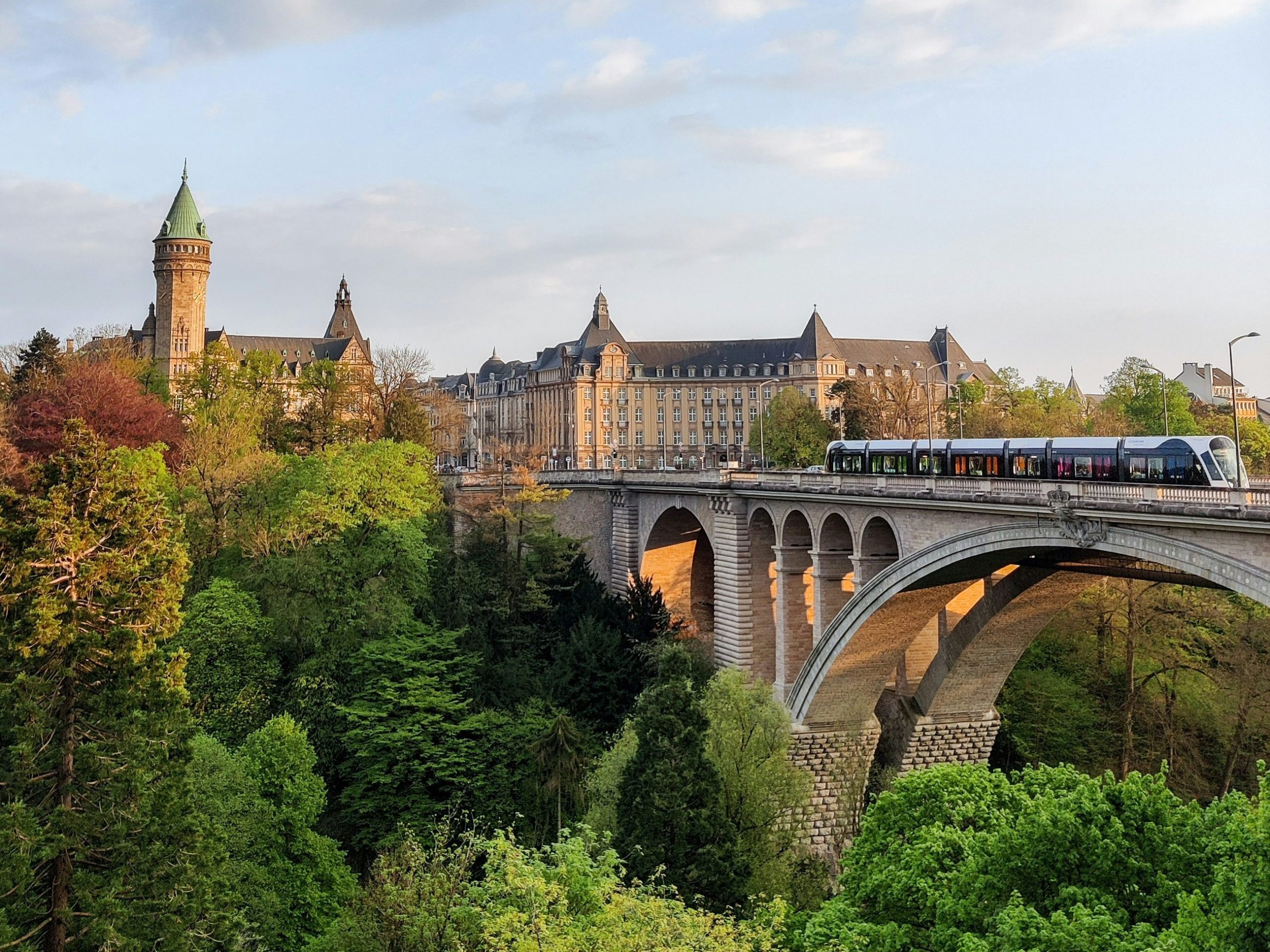 Adolphe Bridge in Luxembourg City with a tram crossing and the State Savings Bank tower in the background