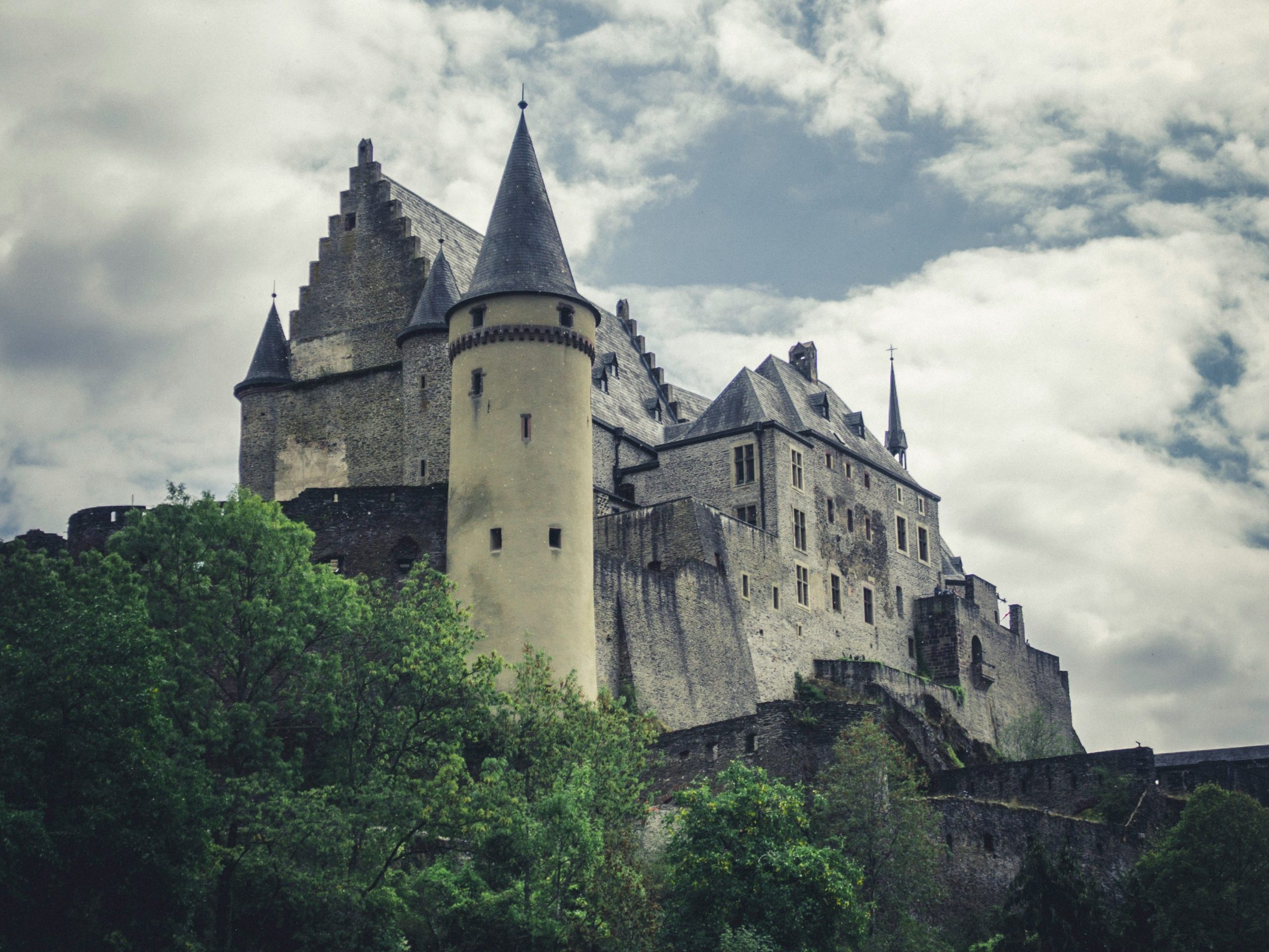 Vianden Castle in Luxembourg viewed from below with dramatic clouds above
