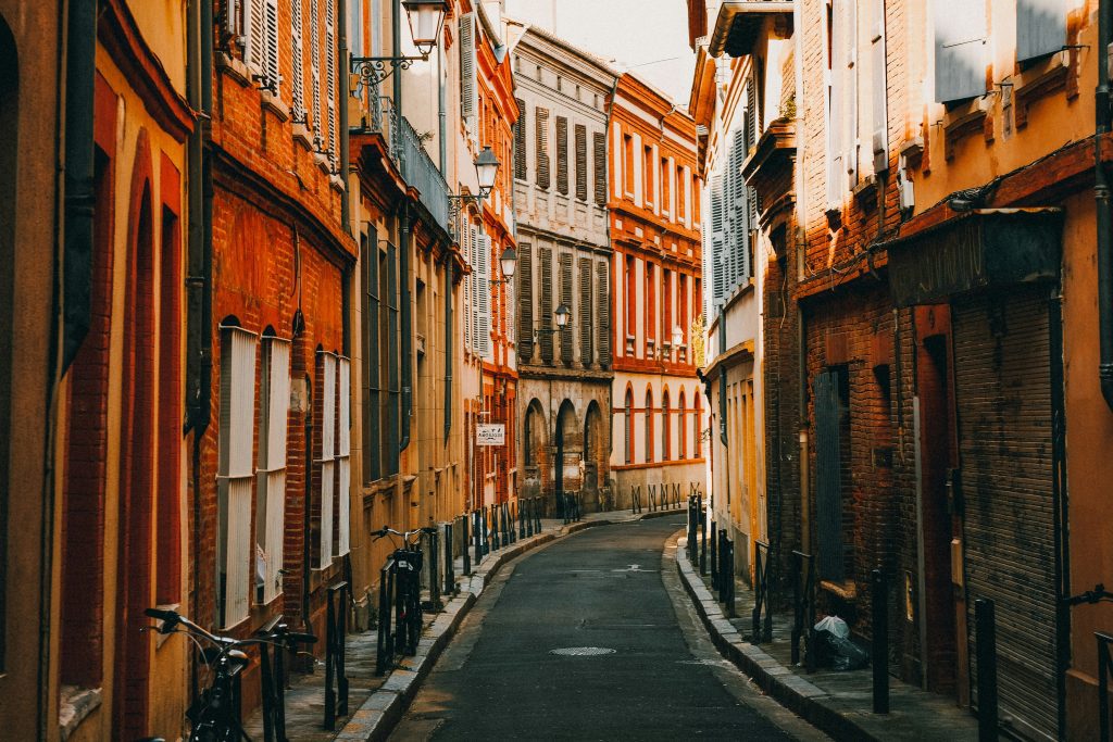 Narrow pink brick street in the historic center of Toulouse with evening light on the buildings
